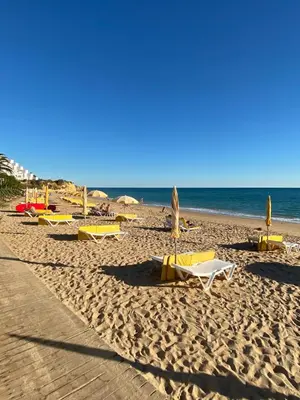 a beach with chairs and umbrellas on the sand at The Strip Oura apartment in Albufeira
