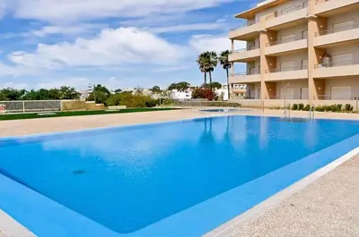 a large blue swimming pool in front of a building at Albufeira - Apartment - Sleeps 4 - Pool - Seaside in Albufeira