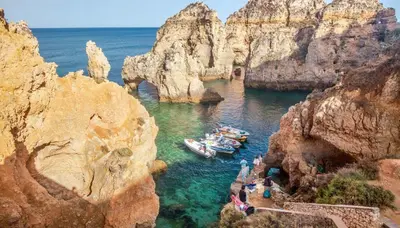 a group of boats in a cave in the water at Albufeira - Apartment - Sleeps 4 - Pool - Seaside in Albufeira