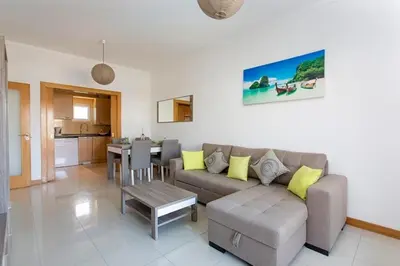 a living room with a couch and a table at Albufeira - Apartment - Sleeps 4 - Pool - Seaside in Albufeira