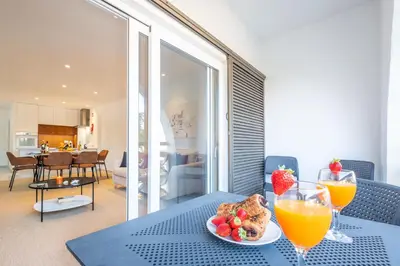 a table with a plate of food and two glasses of orange juice at Apartment Melbourne 2 by Algarve Vacation in Albufeira