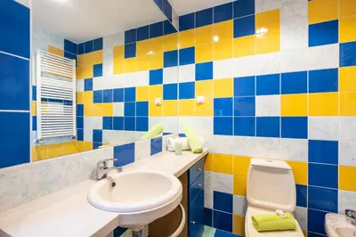 a bathroom with blue and yellow tiles on the wall at Villa Poseidon by Algarve Vacation in Albufeira