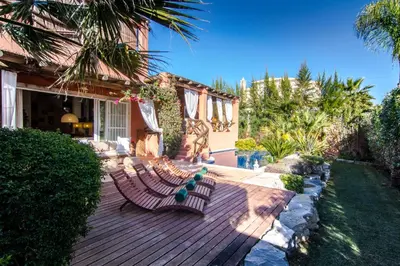 a patio with a pergola with a couch under it at Varandas Do Lago Villa in Almancil