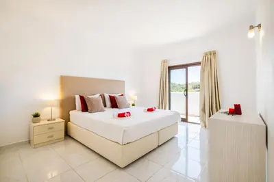 a white bedroom with a large bed and a window at Villa Perola by Algarve Vacation in Albufeira