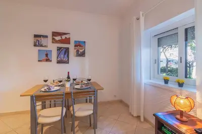 a dining room with a table and chairs and a window at Vilamoura - M M GARDEN - Magnifico T2 in Vilamoura