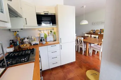 a kitchen with white cabinets and a dining room at Charming Villa by SAPvillas in Vilamoura