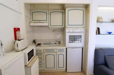 a small kitchen with blue and white cabinets at Marina Mar Navigator by SAPvillas in Vilamoura