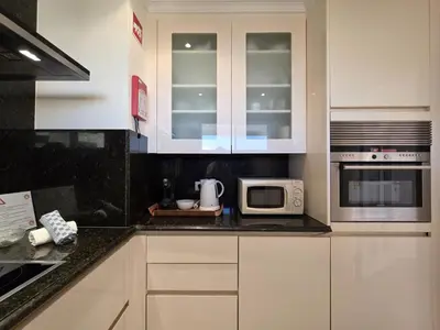 a kitchen with white cabinets and black appliances at Marina Mar Ocean View by SAPvillas in Vilamoura