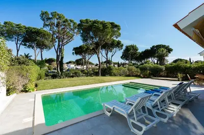 a swimming pool with lounge chairs and trees at Villa Mianas by SAPvillas in Vilamoura