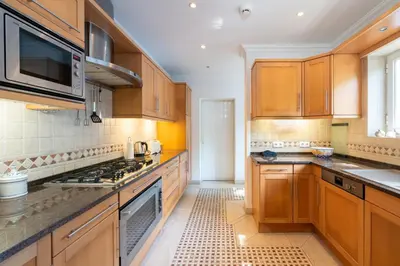 a kitchen with wooden cabinets and a stove top oven at Villa Serendipity by SAPvillas in Vilamoura