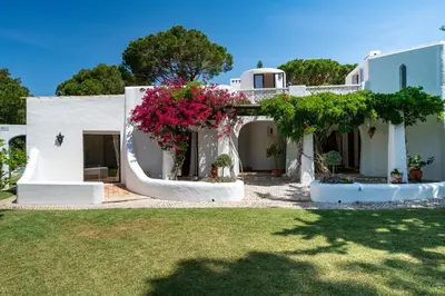 a white house with flowers in a yard at Villa Serendipity by SAPvillas in Vilamoura
