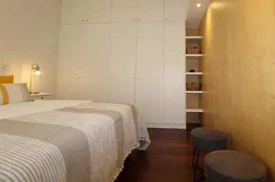a bedroom with a bed and two stools in it at L'Orangerie Green Garden by SAPvillas in Vilamoura