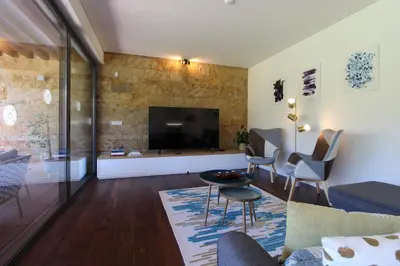 a living room with a tv and a couch and chairs at L'Orangerie Green Garden by SAPvillas in Vilamoura
