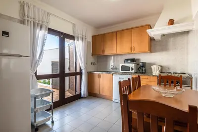 a kitchen with a table and a dining room at Villa Canto II - 500m from the Beach - Private Swimming Pool - Wi Fi in Guia