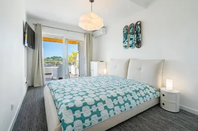 a bedroom with a large bed and a balcony at Albufeira Beach Apartment in Guia
