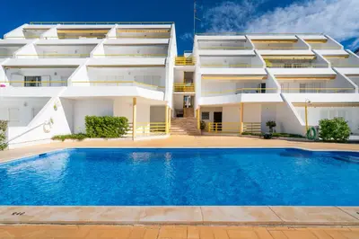 an apartment with a swimming pool in front of a building at Albufeira Beach Apartment in Guia