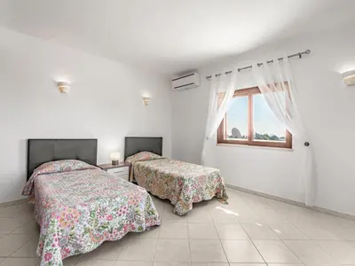 two beds in a white room with a window at Holiday Home Vivenda Deolinda by Interhome in Albufeira