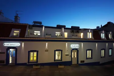 a large white building with windows at night at Apartamentos Tucha in Albufeira