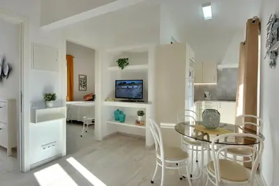 a kitchen and living room with a table and chairs at Apartamentos Tucha in Albufeira