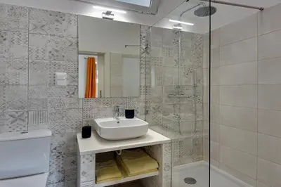 a white bathroom with a sink and a shower at Apartamentos Tucha in Albufeira