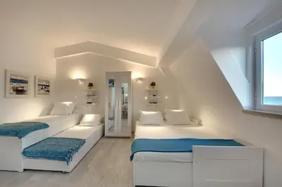 two beds in a room with white walls at Apartamentos Tucha in Albufeira