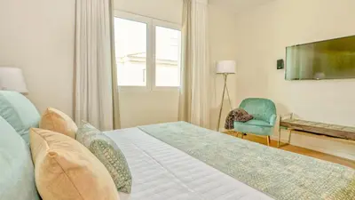 a bedroom with a bed and a tv and a chair at Dream Villa with Luxury Services - PROMOTION Last dates! in Vilamoura
