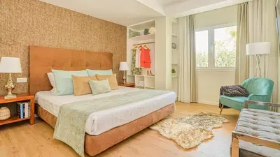 a bedroom with a large bed and a chair at Dream Villa with Luxury Services - PROMOTION Last dates! in Vilamoura