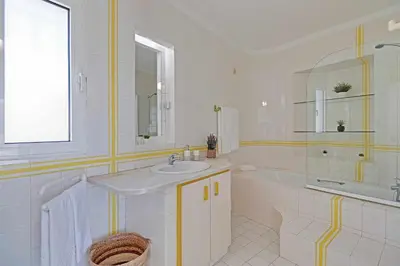 a white bathroom with a sink and a tub and a mirror at Villux - Vila Enar-6 quartos, ideal para familias in Albufeira