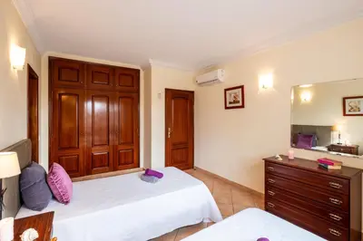 a bedroom with two beds and a dresser and a mirror at Villa Bali by Algarve Vacation in Albufeira