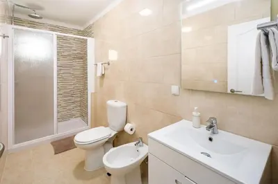 a bathroom with a toilet and a sink and a shower at Apartamento Vista Mar T2 in Quarteira