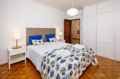 a bedroom with a large bed with blue and white sheets at Apartamento Vista Mar T2 in Quarteira