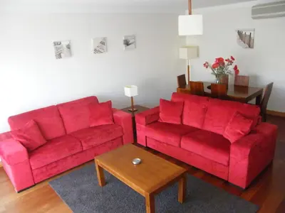 a bedroom with a bed with blue sheets and a window at Luxurious first floor apartment with balconies overlooking pool and gardens. in Albufeira