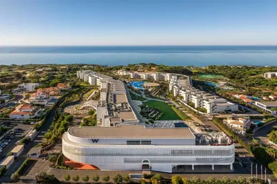 an aerial view of a building next to the ocean at W Residences Algarve in Albufeira