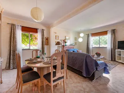 a bedroom with a bed and a table and a dining room at Holiday Home Isaurinda by Interhome in Faro