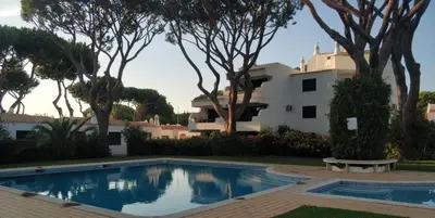 a villa with a swimming pool in front of a house at Solar dos Pinheiros LC 303 in Quarteira