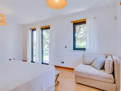 a white living room with a couch and a table at Vale do lobo, 'Golf by the Pool' 2 bedroom apartment in Vale do Lobo