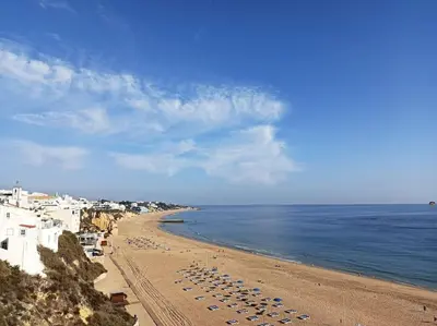 a beach with a bunch of chairs and the ocean at Sea & Sun OldTown in Albufeira