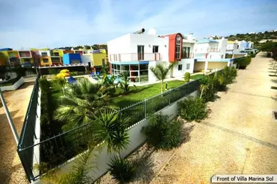 a group of houses with palm trees in a city at Marina Sol by Atlantic Places in Albufeira