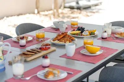 a table with plates of breakfast foods and glasses of orange juice at Villa Flamingo - Quinta do Mar in Almancil