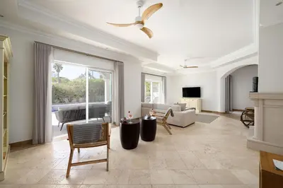 a living room with a large window and a couch at Villa Flamingo - Quinta do Mar in Almancil
