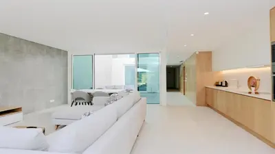 a living room with white couches and a kitchen at Villa Sadler- Clever Details, Central Vilamoura, Sleeps 6, luxury, walking distance in Vilamoura