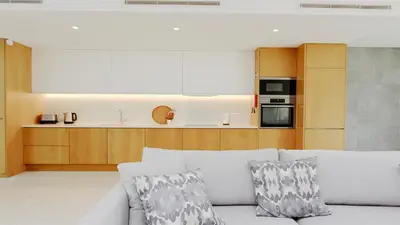 a living room with a couch and a kitchen at Villa Sadler- Clever Details, Central Vilamoura, Sleeps 6, luxury, walking distance in Vilamoura