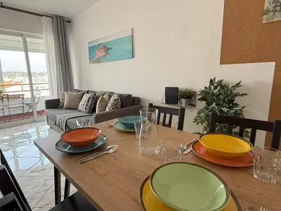 a table with plates and bowls on it in a living room at Go4Portugal - Lagoa - Apartment 3 min from beach with airco and balcony in Quarteira