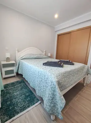 a bedroom with a bed with a blue comforter at Alojamento King´s Village in Albufeira