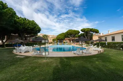 a pool with chairs and umbrellas in a yard at Pedra dos Bicos by Intiholidays in Albufeira