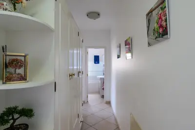 a hallway with white walls and a bathroom with a toilet at Pedra dos Bicos by Intiholidays in Albufeira