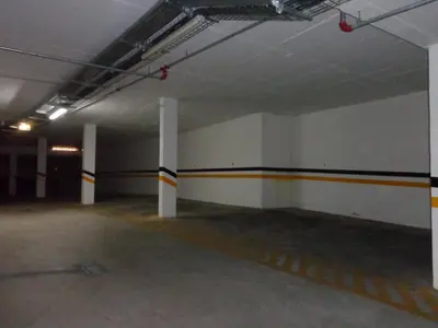 an empty parking garage with white walls and orange and white columns at Santa Maria G by Check-in Portugal in Albufeira