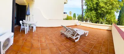 a patio with chairs and a table on a house at Albufeira Garden in Albufeira