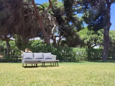a white couch sitting in the grass in a field at Vilamoura Golf Mansion by Stay ici Algarve Holiday Rental in Quarteira