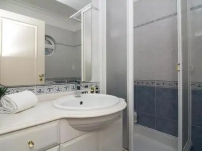 a white bathroom with a sink and a shower at Vilamoura Golf Mansion by Stay ici Algarve Holiday Rental in Quarteira